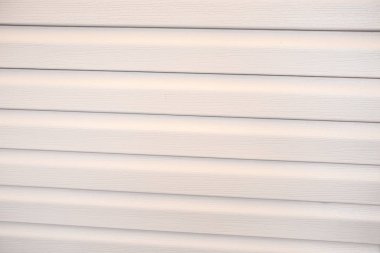 Uzun paralel yatay ayrıntılarla yeni bej dış cephe duvar parçası  