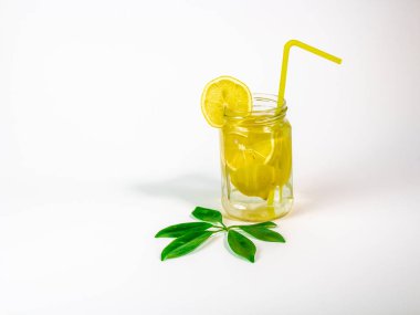 Beyaz zemin üzerine sarı saman bir Mason kavanoza limonata
