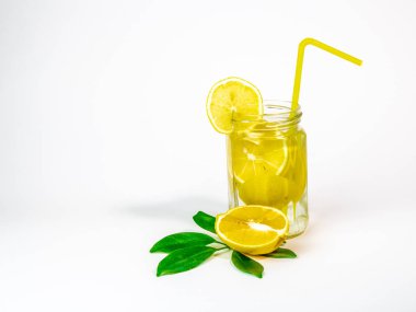 Beyaz zemin üzerine sarı saman bir Mason kavanoza limonata