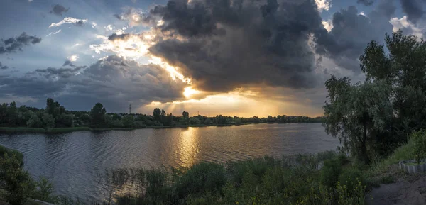 dark stormy clouds over lake during sunset
