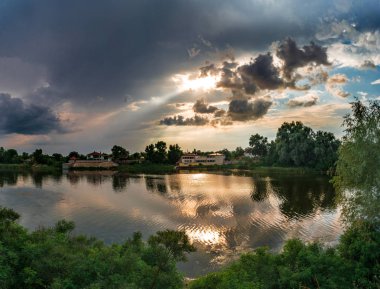 göl günbatımı sırasında üzerinde karanlık fırtınalı bulutlar