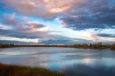 göl günbatımı sırasında üzerinde karanlık fırtınalı bulutlar