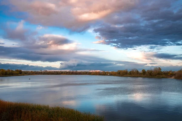 göl günbatımı sırasında üzerinde karanlık fırtınalı bulutlar