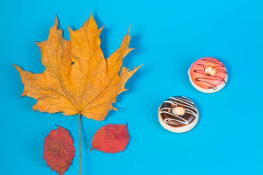 çörek ve sonbahar yaprakları üzerinde mavi arka plan