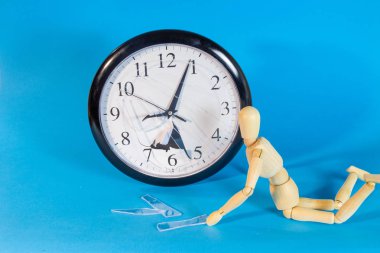 Mavi arka plan üzerinde bozuk saat ahşap manken