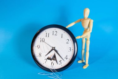 Mavi arka plan üzerinde bozuk saat ahşap manken