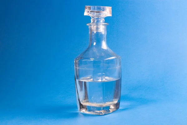 青の背景に液体ガラスの瓶 — ストック写真