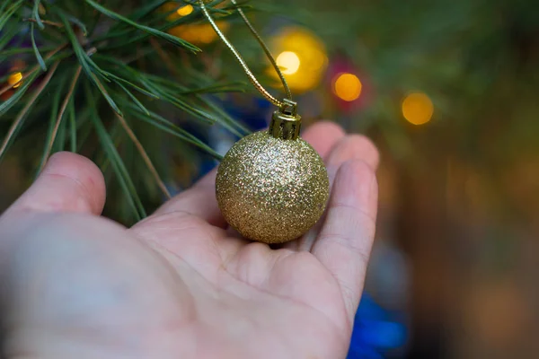 Mão Segurando Bola Natal Dourada Fundo Festivo Borrado — Fotografia de Stock