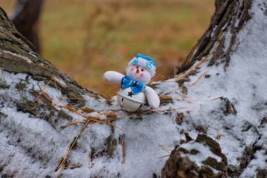 Ahşap ağaç gövdesi üzerinde Noel oyuncak kardan adam görünümü kadar kapatın