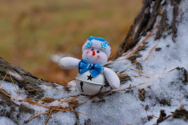 Ahşap ağaç gövdesi üzerinde Noel oyuncak kardan adam görünümü kadar kapatın