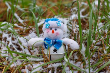 Noel oyuncak kardan adam çimenlerin üzerinde karla kaplı