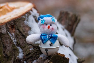 Ahşap ağaç gövdesi üzerinde Noel oyuncak kardan adam görünümü kadar kapatın