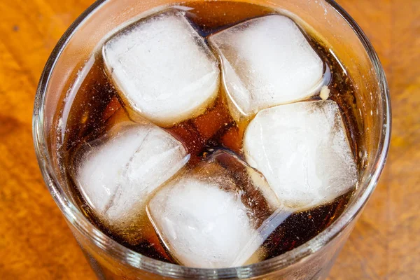 black carbonated drink with ice cubes