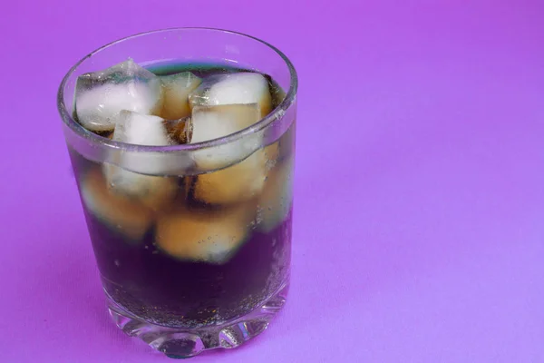 black carbonated drink with ice cubes