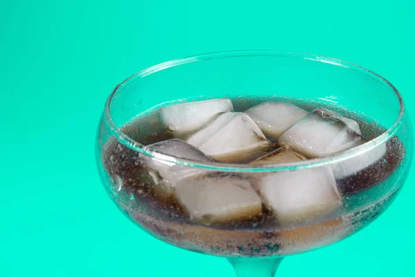 black carbonated drink with ice cubes