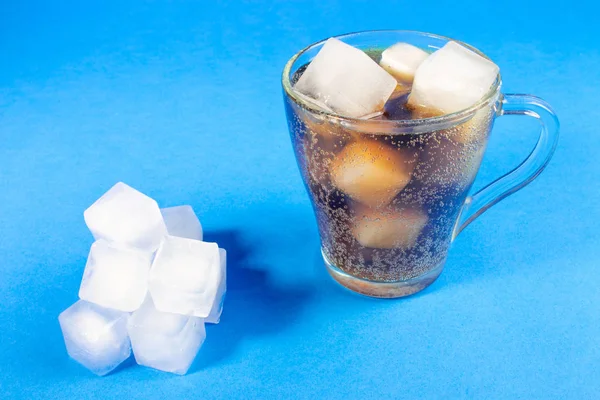 black carbonated drink with ice cubes, cold cocktail