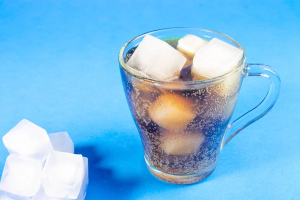 black carbonated drink with ice cubes, cold cocktail