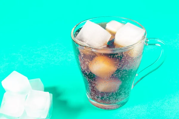 black carbonated drink with ice cubes, cold cocktail