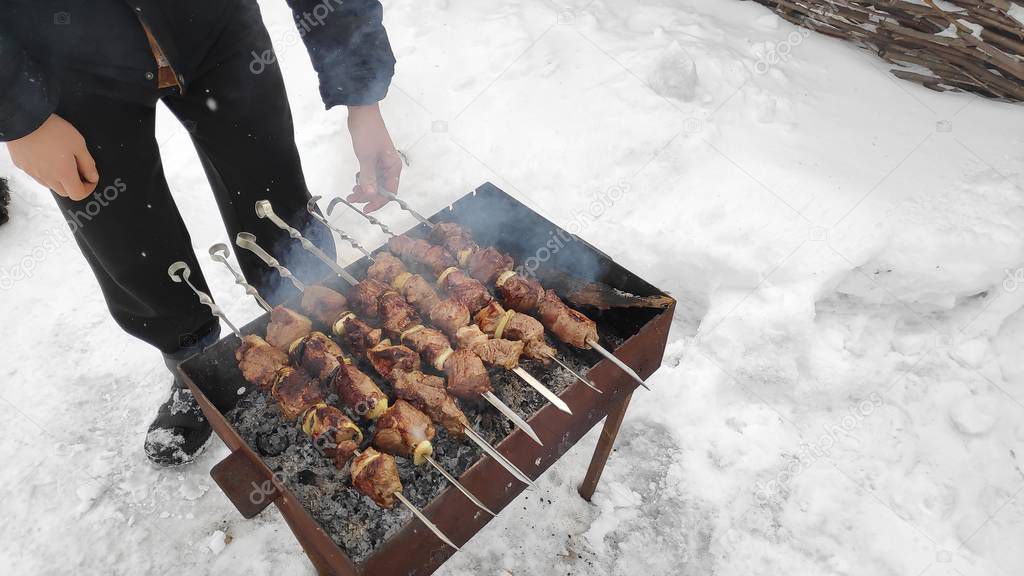 tasty grilled meat on the fire, shish kebab in winter, cooking meat