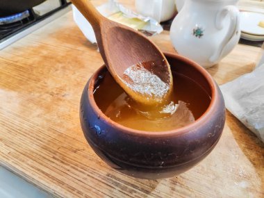 toprak kap bal, bir tahta kaşık bal ile