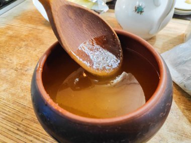 toprak kap bal, bir tahta kaşık bal ile