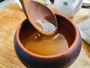 toprak kap bal, bir tahta kaşık bal ile