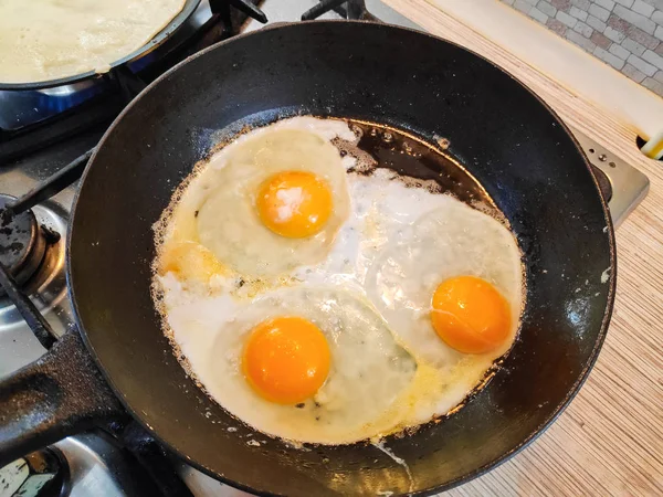 fried eggs in a pan, cooking scrambled eggs,