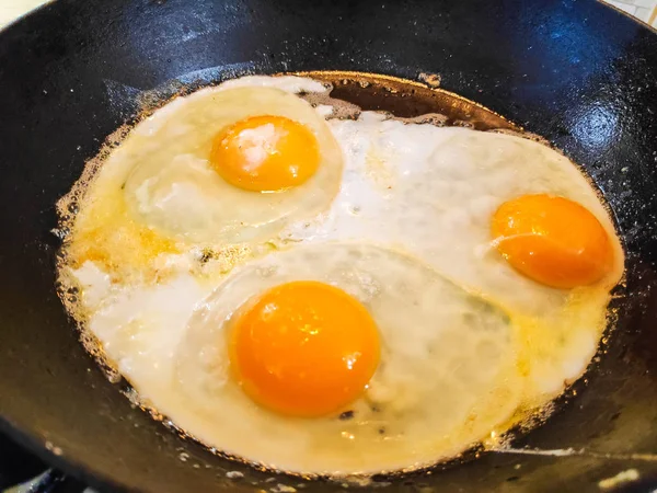 fried eggs in a pan, cooking scrambled eggs,
