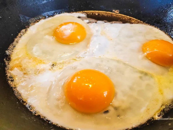 fried eggs in a pan, cooking scrambled eggs,