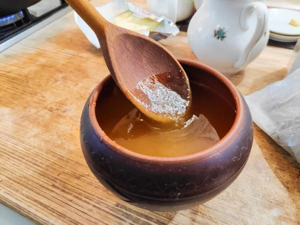 toprak kap bal, bir tahta kaşık bal ile