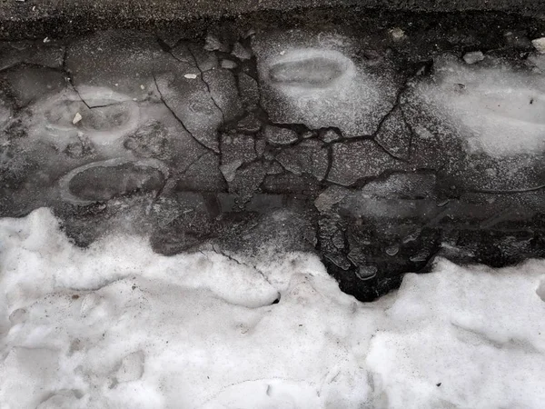 在雪地上的大水坑 雪融化 在冰上的脚印 春天解冻 — 图库照片