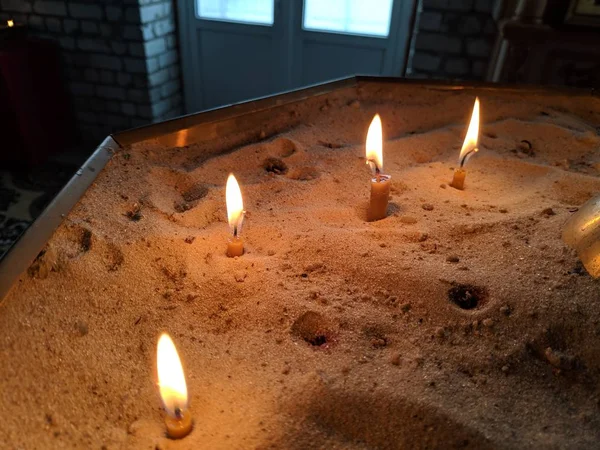 Candlescandles は砂の中に燃えています — ストック写真