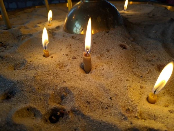 Candlescandles は砂の中に燃えています — ストック写真