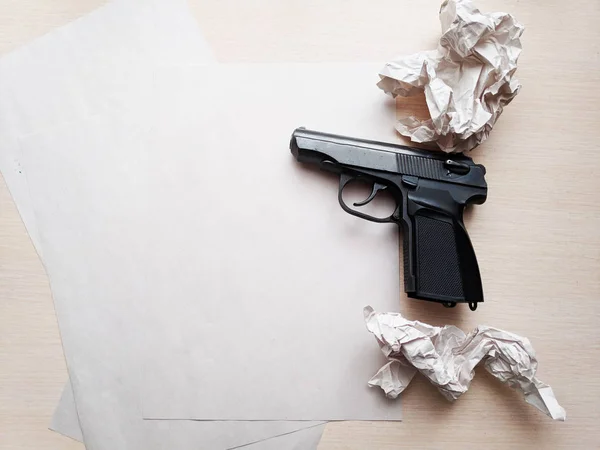 gun on the table, gun and paper, blood on paper and gun