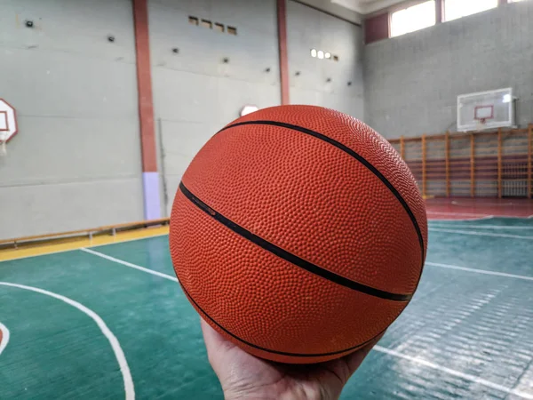 Basketball. Basketball court. Hand holding ball