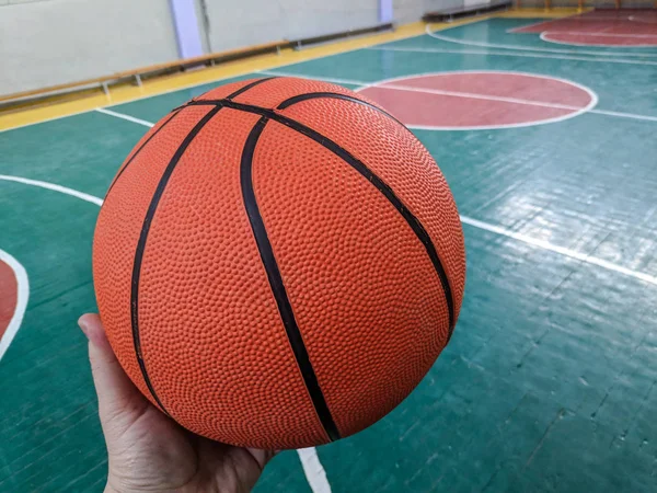 Basketball. Basketball court. Hand holding ball