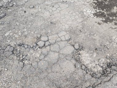 çok kötü asfalt yol. yolda derin çukurlar. kötü onarım. çatlak asfalt