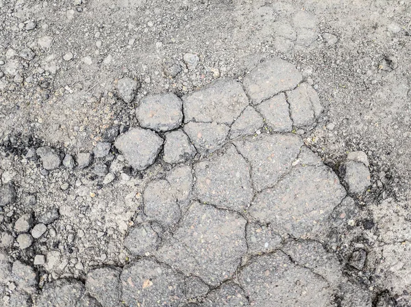 very bad asphalt road. deep pits on the road. bad repair. cracked asphalt