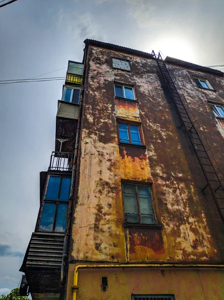 very old high-rise building. rusty metal fire escape. housing for the poor.