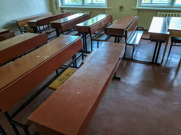 vintage tables and chairs. old classroom. lecture hall. student audience. antique desks