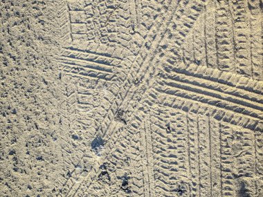 Yolda araba lastiklerinin izleri var. kumaraba ayak izleri.