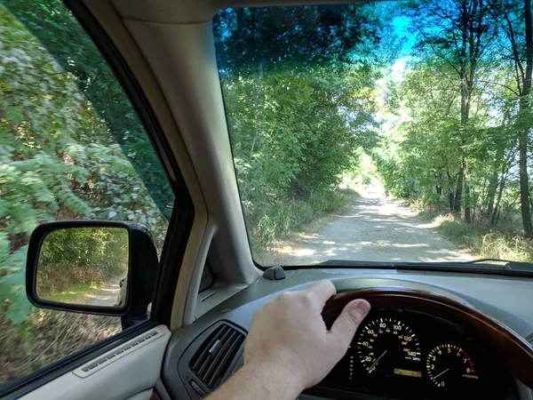 riding inside a car. vehicle interior. driver rides on a dirt road.
