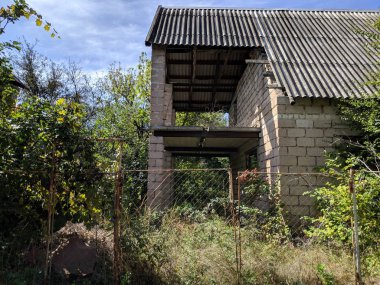 eski harap özel ev. ağaçların bir çalılık ta bitmemiş tuğla ev