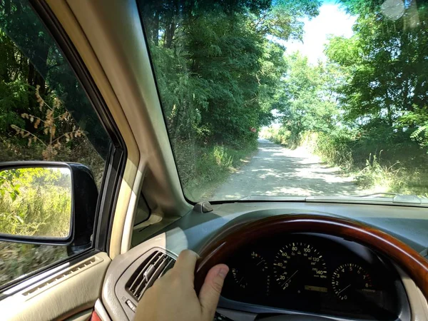 riding inside a car. vehicle interior. driver rides on a dirt road.