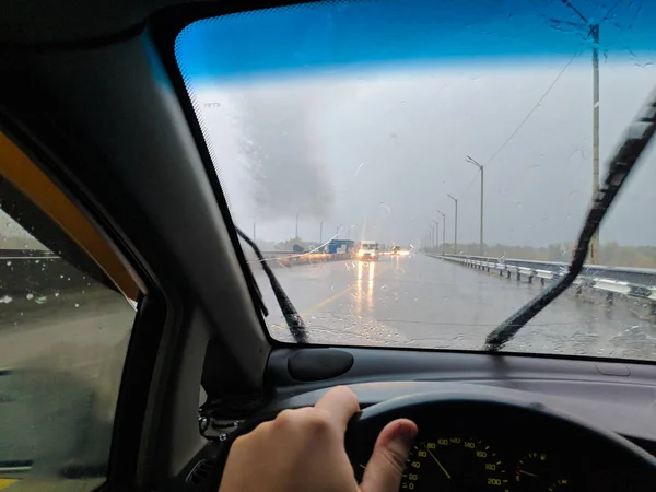 driving a car in the rain. rain and bad weather. wet road