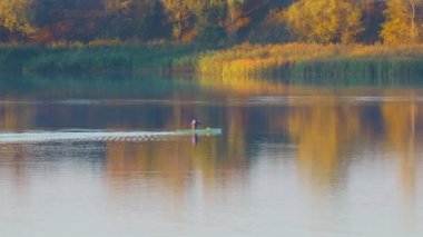 Kano yapıyorum. Kano eğitimi. Kürekleri suda olan bir tekne. Sporcu bir teknede yüzüyor..