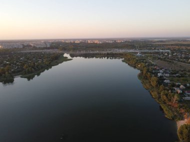 Günbatımlı akşam manzarası. Nehir ve güneş yukarıdan. Bir yaz akşamında insansız hava aracıyla manzara