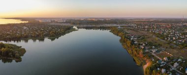 Günbatımlı akşam manzarası. Nehir ve güneş yukarıdan. Bir yaz akşamında insansız hava aracıyla manzara