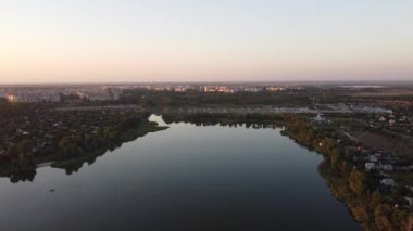 Günbatımlı akşam manzarası. Nehir ve güneş yukarıdan. Bir yaz akşamında insansız hava aracıyla manzara