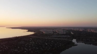 Günbatımlı akşam manzarası. Nehir ve güneş yukarıdan. Bir yaz akşamında insansız hava aracıyla manzara